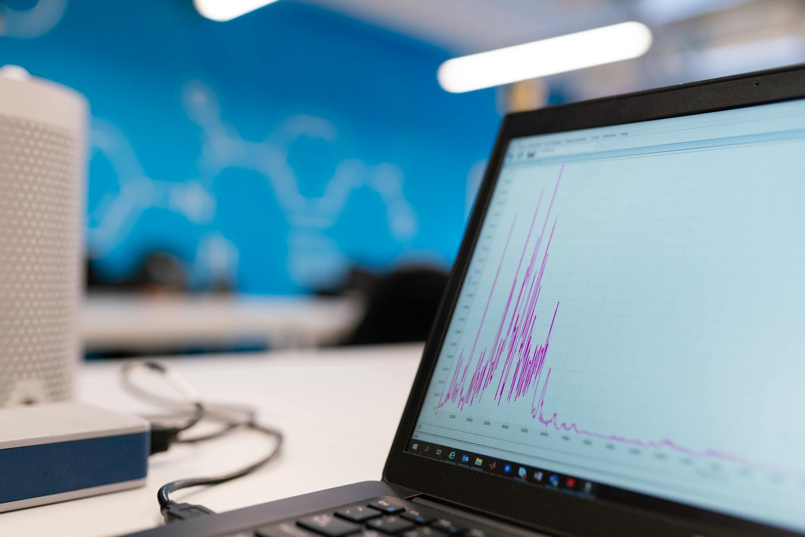 Tablero digital con KPIs de calidad e IA visible sobre laptop en oficina industrial
