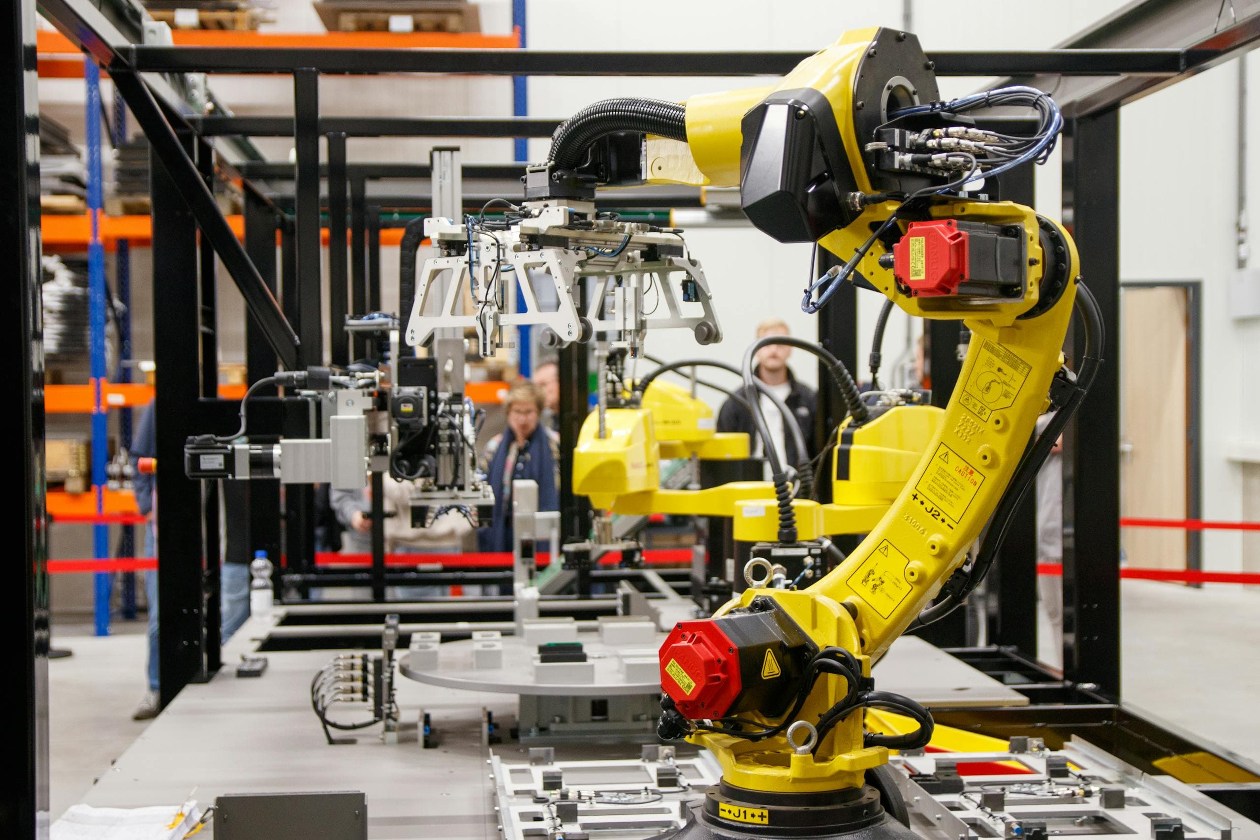 Línea de ensamble automotriz con brazos robóticos en operación